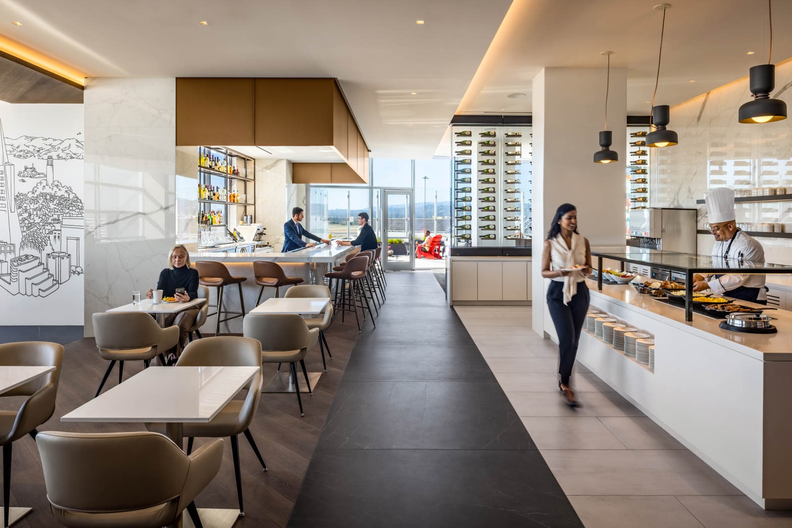 A woman surveys the options at a buffet in a restaurant style dining room.