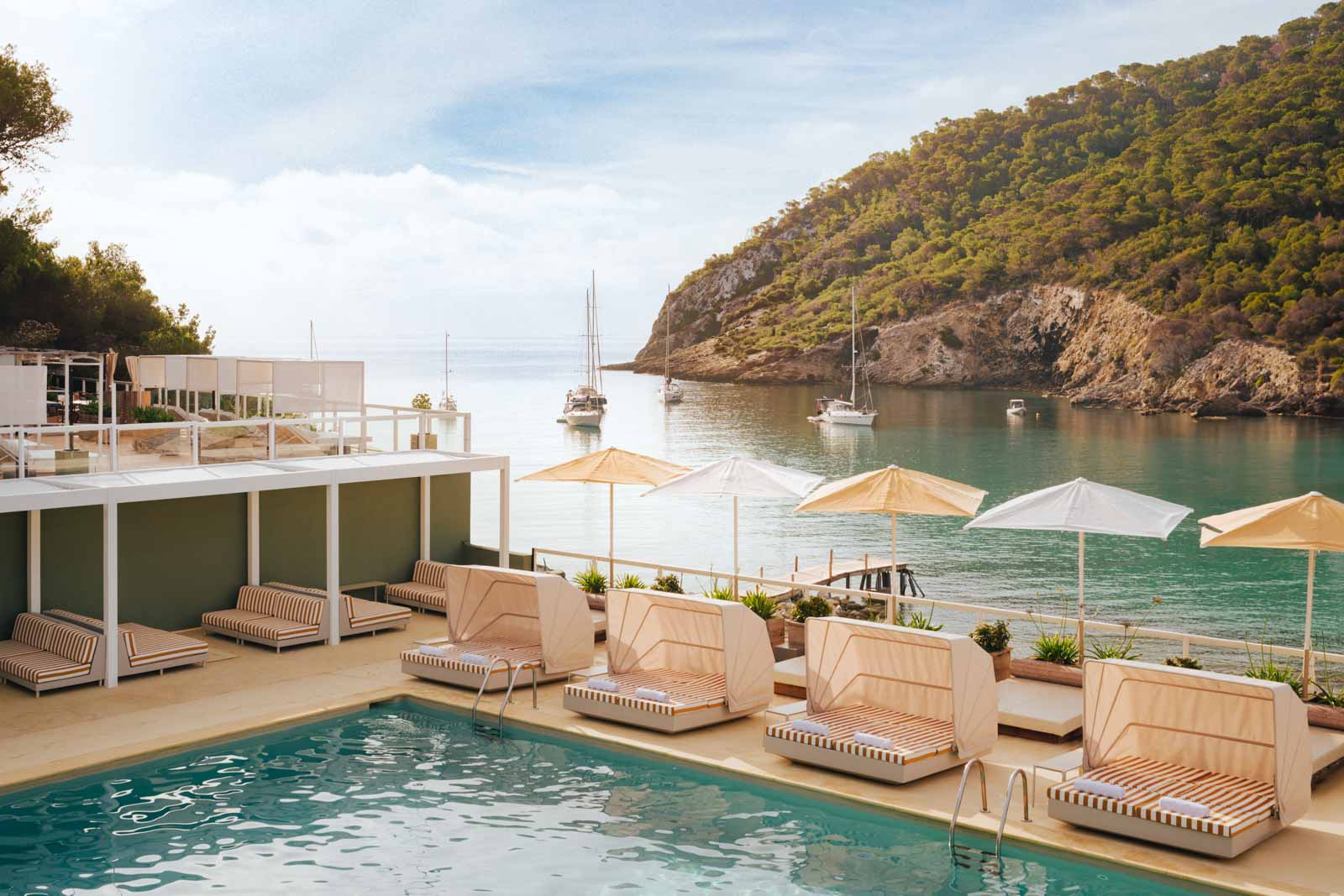 Pool with lounge chairs near bay